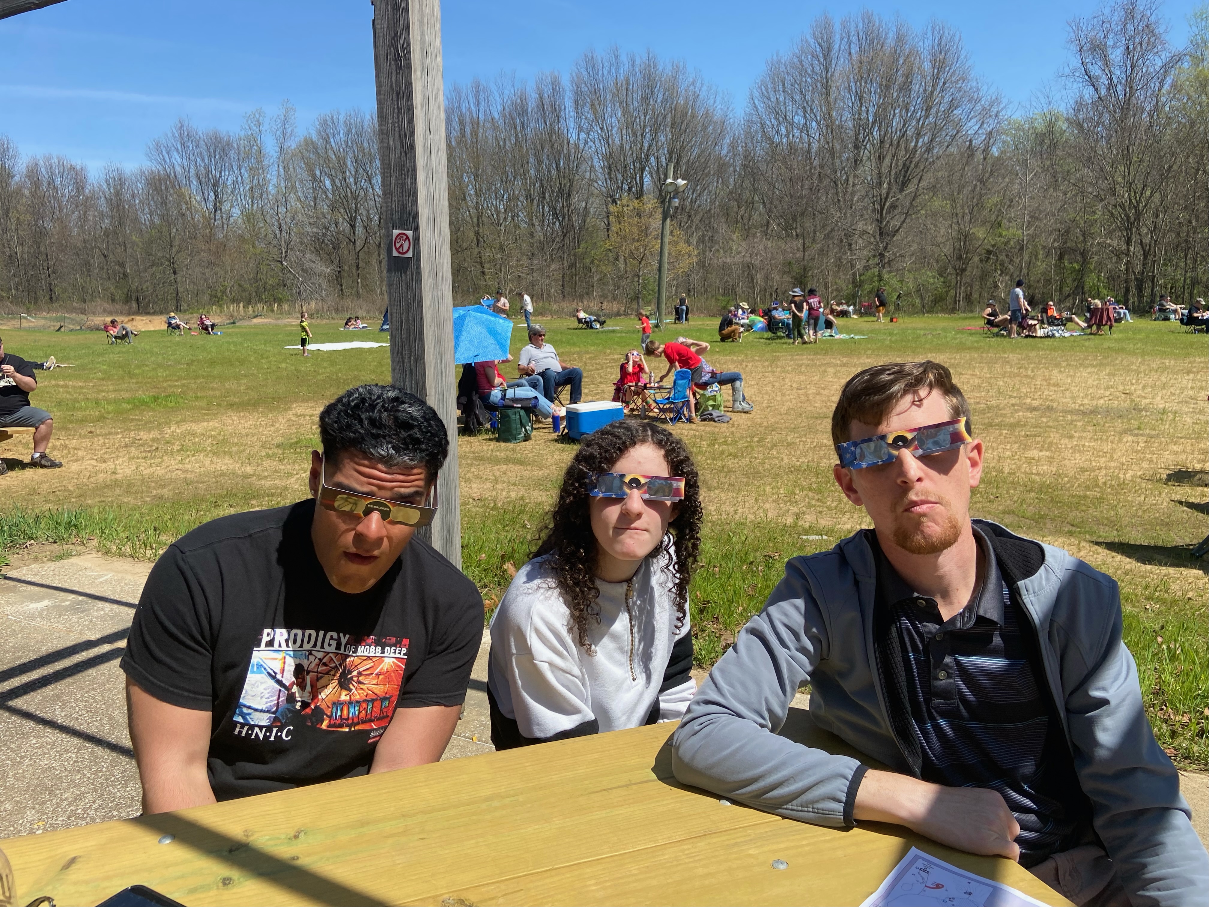 Three of us wearing cheesy smiles and cheesy (but critical) solar-filtering eclipse glasses just before the 2024 total solar eclipse